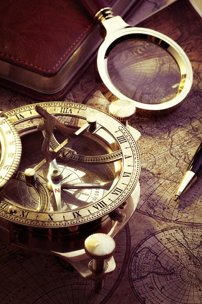Old vintage compass and travel instruments on ancient map