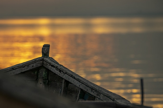 Free photo old weathered boat for fishing on the water at sunset