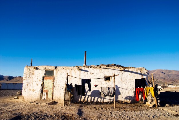 Old weathered house with mountain range in the background