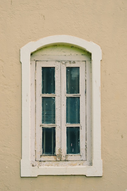 Old white window on a light pink wall