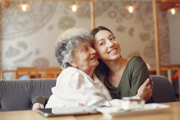 Old woman in a cafe with young granddaughter