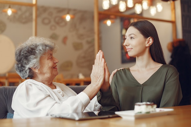 Old woman in a cafe with young granddaughter