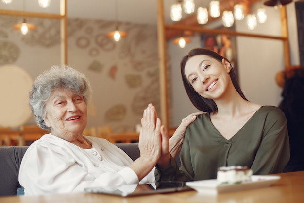 Old woman in a cafe with young granddaughter