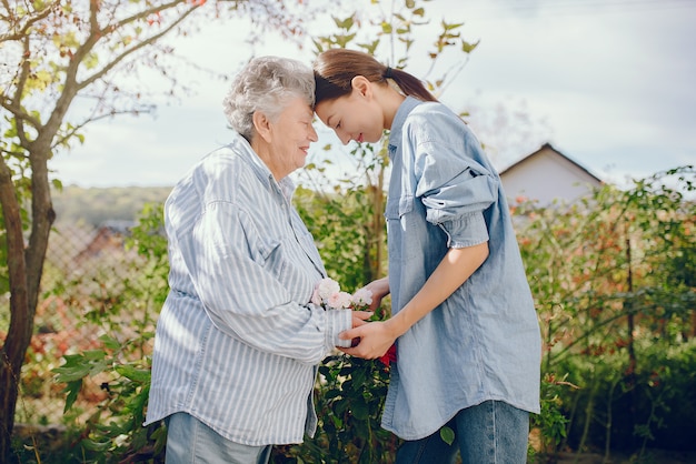 Free photo old woman in a garden with young granddaughter