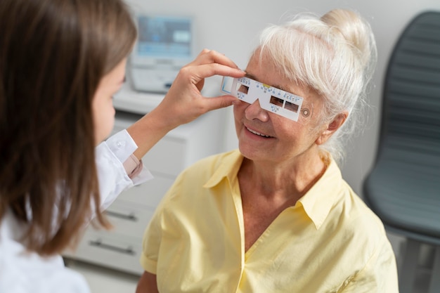 Пожилая женщина проверяет зрение в офтальмологической клинике