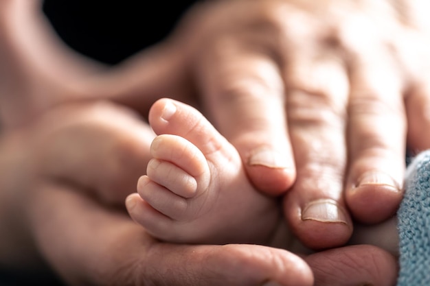 The old woman holds the childs legs in her hands