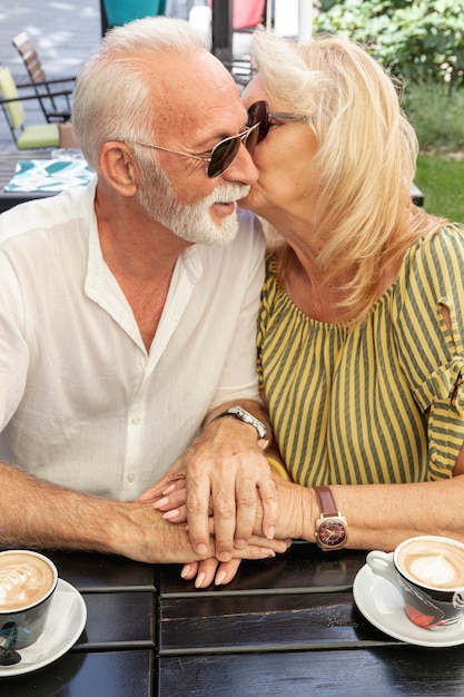 Free photo old woman kissing her husband on the cheek