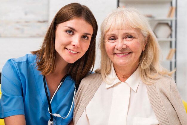 Old woman and nurse looking at the camera