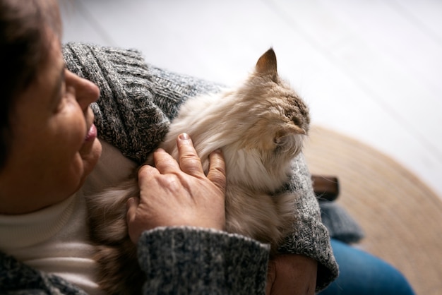 Foto gratuita angolo alto del gatto che accarezza la donna anziana