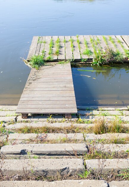 Old wooden dock with over murky water