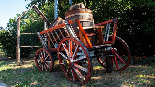 An old wooden wagon with wooden wheels and barrels inside in Varul cel Mic, Moldova