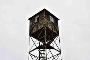 Foto gratuita vecchia torre di guardia in legno contro il cielo nuvoloso