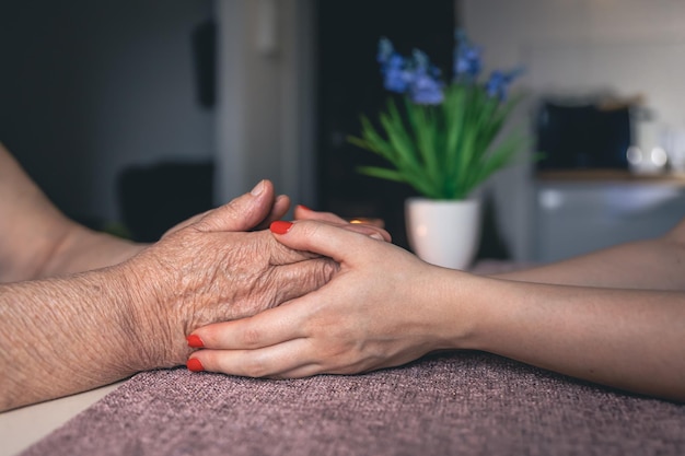 Free photo old and young man holding hands close up