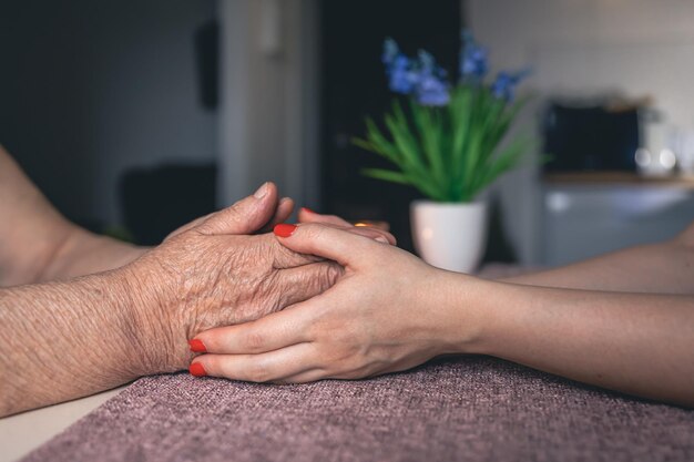 Old and young man holding hands close up