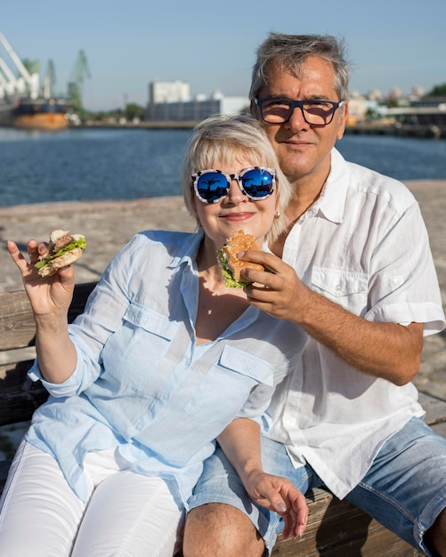 Пожилая пара, наслаждаясь гамбургером на открытом воздухе вместе