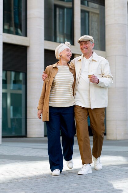 Older couple outdoors in the city with a cup of coffee