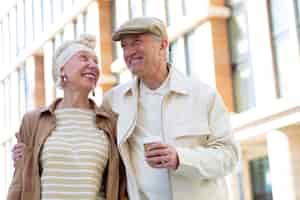 Free photo older couple outdoors in the city with a cup of coffee