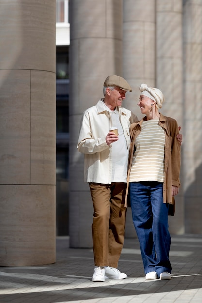 Older couple outdoors in the city with a cup of coffee