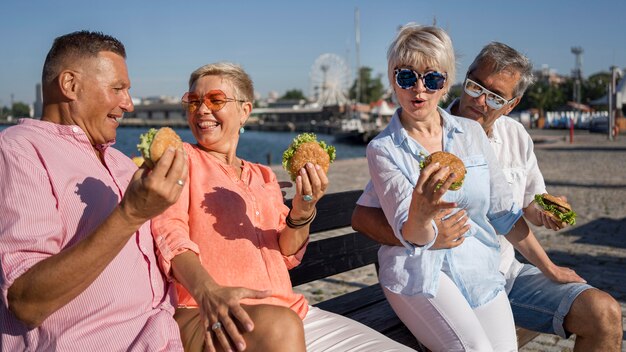 Older couples at the beach enjoying burgers