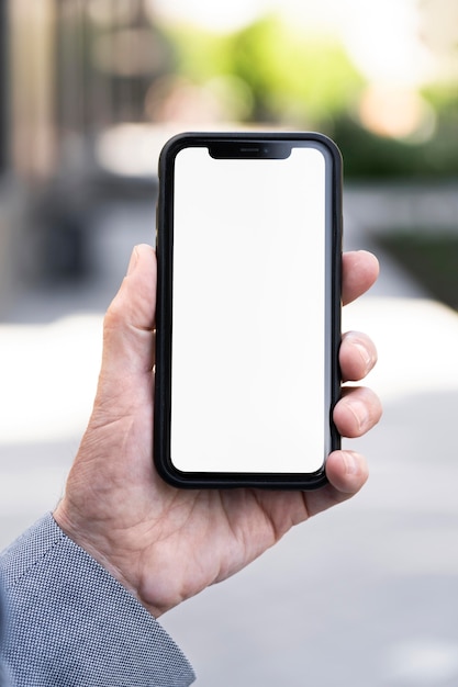 Free photo older man in the city holding smartphone