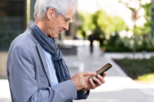 Older man in the city using smartphone