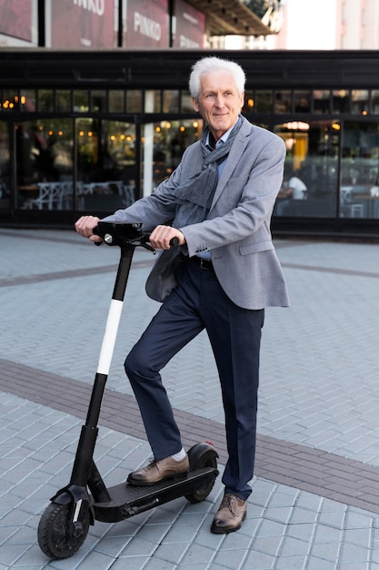 Older man in the city with  electric scooter