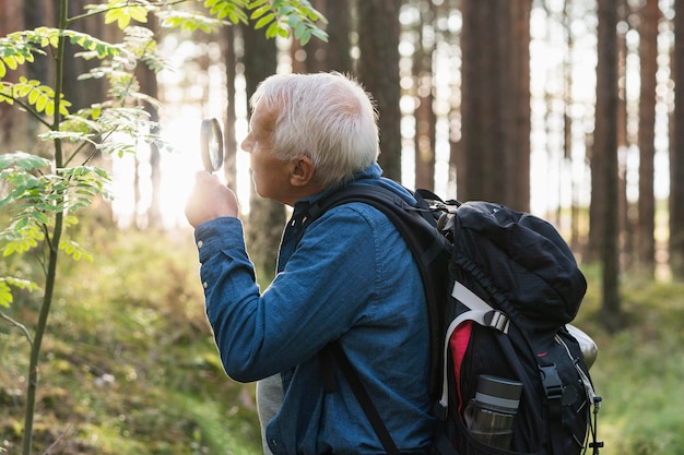 Older man exploring nature with magnifying glass