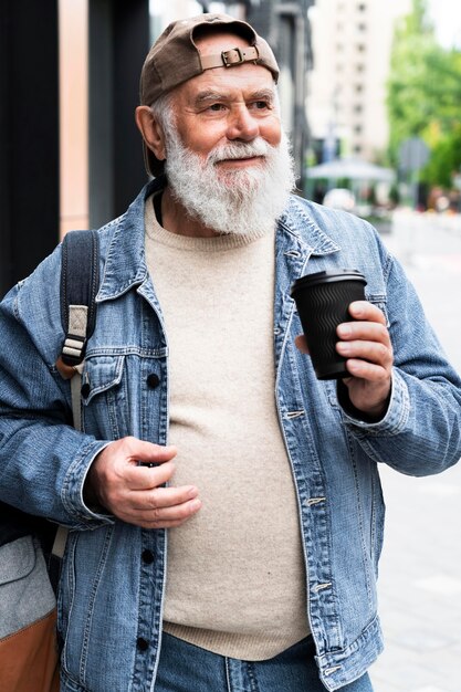 Older man having a cup of coffee outdoors in the city