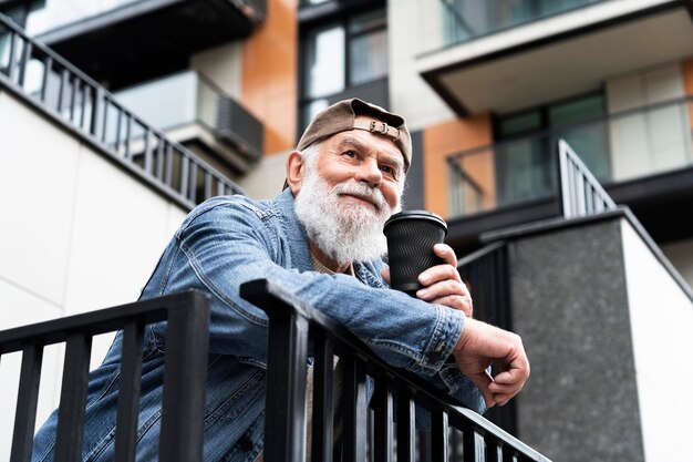 Older man having a cup of coffee outdoors in the city
