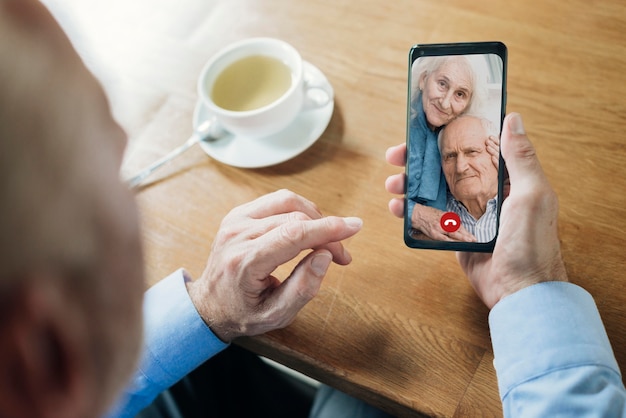 Older man talking to his friends through a video call