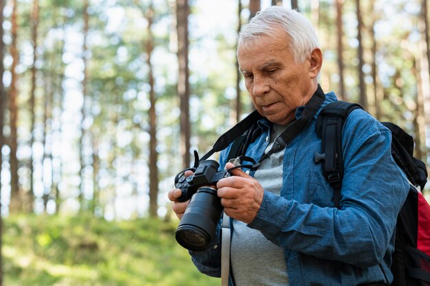 Пожилой мужчина, путешествующий на открытом воздухе с камерой