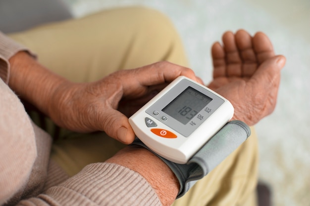 Free photo older person checking their blood pressure with tensiometer