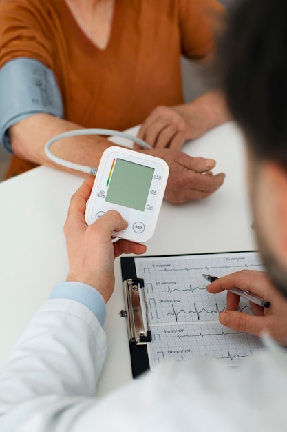 Free photo older person checking their blood pressure with tensiometer