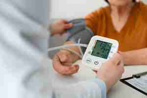 Free photo older person checking their blood pressure with tensiometer