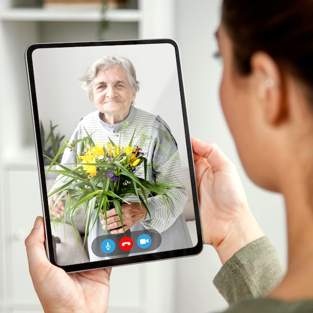 Foto gratuita persona anziana che utilizza la funzione di videochiamata sul proprio dispositivo