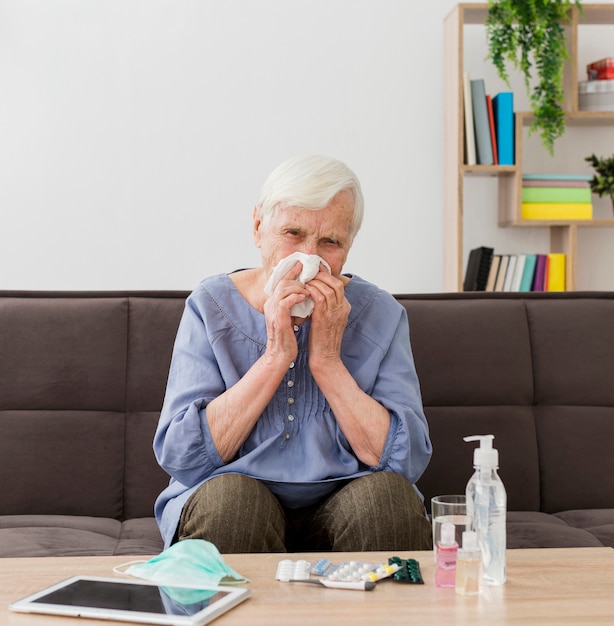 Older woman at home blowing her nose