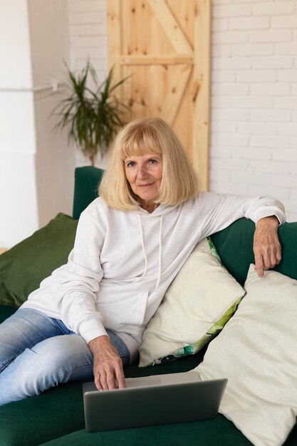 Older woman at home on the sofa with laptop