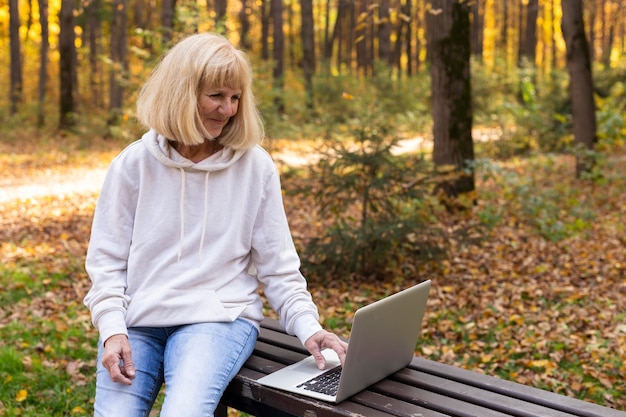 Older woman outdoors using laptop