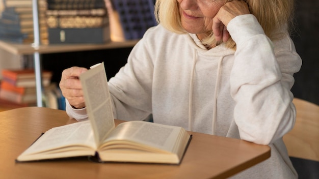 Foto gratuita donna anziana che legge a casa