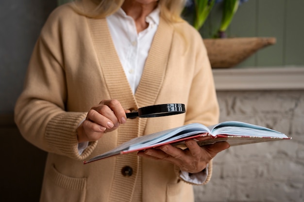 Older woman reading while using a magnifying glass