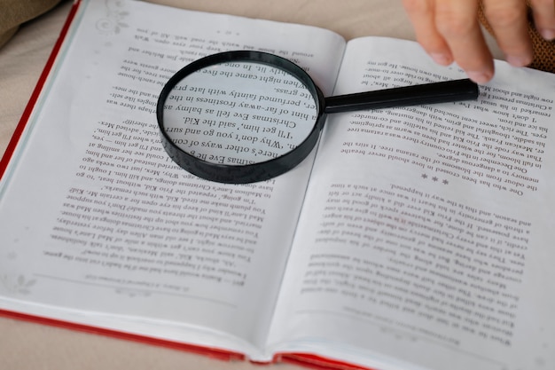 Free photo older woman reading while using a magnifying glass