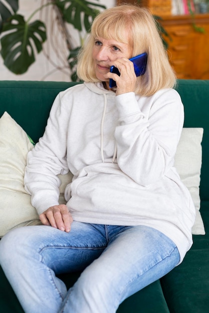 Foto gratuita donna anziana che parla al telefono a casa