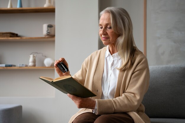 虫眼鏡を使って本を読む年配の女性