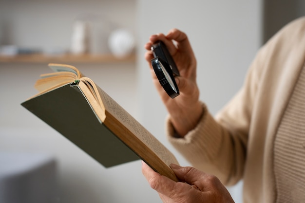 Older woman using a magnifying glass to read