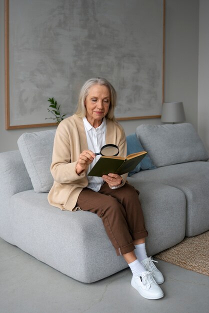 虫眼鏡を使って本を読む年配の女性