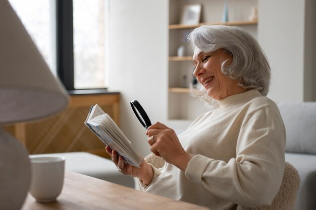 虫眼鏡を使って本を読む年配の女性