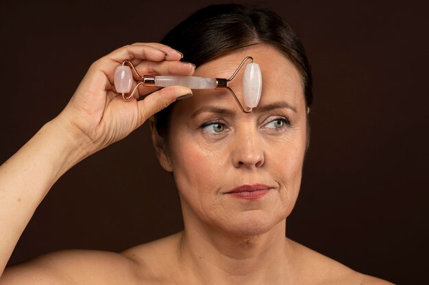 Older woman using rose quartz roller on her face