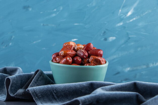 Oleaster in a bowl on a piece of fabric, on the marble surface