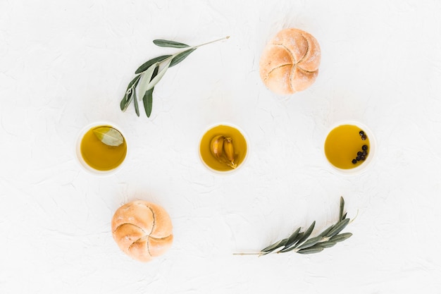 Olive, garlic and black pepper oil in bowl with two buns