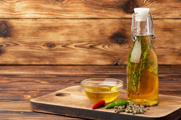 Оливковое масло и специи на деревянном фоне